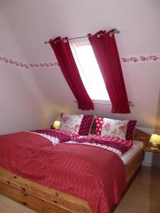a bedroom with a red bed with a window at Fliegender Holländer in Juist