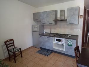 a small kitchen with a stove and a microwave at Casa Vacanza Marco Gianola Formia in Formia