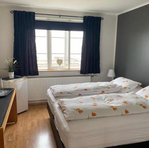 Un pat sau paturi într-o cameră la Grenivik Guesthouse