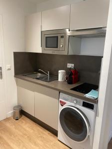 uma cozinha com uma máquina de lavar roupa e um micro-ondas em Appartement hypercentre 4 personnes 30 m2 em Lille