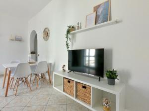 uma sala de estar com uma televisão de ecrã plano num armário branco em La Casetta sul Golfo em Sferracavallo