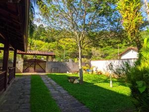 a garden with a tree and a stone pathway at Espaço 579 in Miguel Pereira