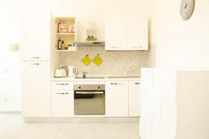 eine weiße Küche mit weißen Schränken und einem Waschbecken in der Unterkunft Guest House Oasi Dei Mille in Reggio nell'Emilia