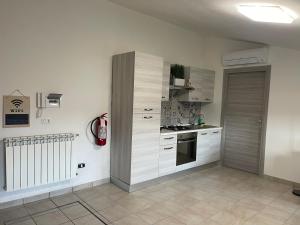a kitchen with white cabinets and a stove at Oceania apartments in Grosseto