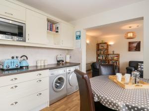 eine Küche mit einem Tisch und einer Waschmaschine in der Unterkunft Rothay in Ambleside