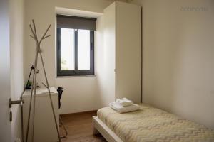 Habitación pequeña con cama y ventana en 12 Casa d'Avó, en Albergaria-a-Velha