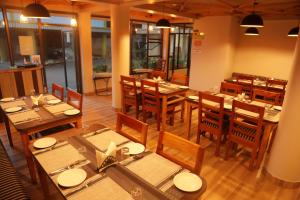 una sala da pranzo con tavoli e sedie in legno di The Phoenix Residency a Shillong