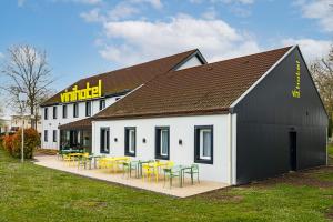 a building with tables and chairs in front of it at Vini Hotel in Beaune