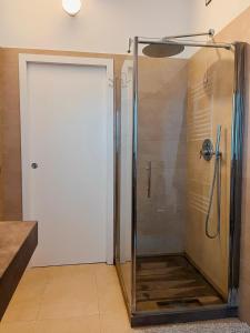 La salle de bains est pourvue d'une douche avec une porte en verre. dans l'établissement Cottage indipendente con piscina privata, à Masi San Giacomo