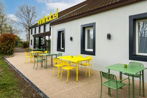 a group of tables and chairs in front of a building at Vini Hotel in Beaune