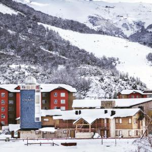 a resort with snow covered mountains in the background at Galileo Boutique Hotel in San Carlos de Bariloche