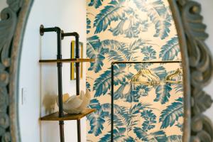 a mirror in a room with a blue and white wallpaper at Numero Uno Beach House in San Juan