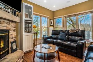 a living room with a leather couch and a fireplace at Beach House in Saugatuck