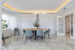 a dining room with a table and blue chairs at Edén Costa Lago PRIMERA LÍNEA DE MAR in Torremolinos