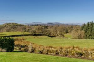 een veld van groen gras met een hek bij Cleabarrow View in Windermere