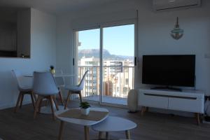 a living room with a flat screen tv and a large window at Calpe Beachview in Calpe
