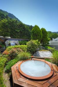 a hot tub in the middle of a garden at Kinugawa Grand Hotel Yumenotoki in Nikko