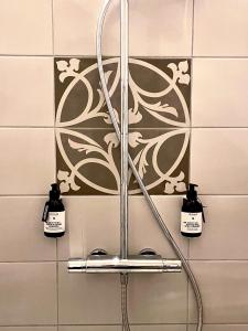 a shower head in a bathroom with two lights at Suite Living Boardinghouse Apartments in Gießen