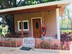 una pequeña casa con porche y puerta en Hilamito Lodge, en Tela