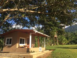 ein kleines Haus auf einem Feld mit einem Baum in der Unterkunft Hilamito Lodge in Tela