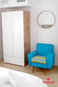 a blue chair in a room with a mirror at Apartamento Caracol - CORDOBA in Córdoba
