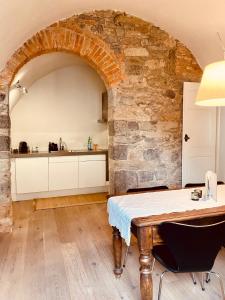 a kitchen with a table and a stone wall at Guesthouse Castagnola in Lugano