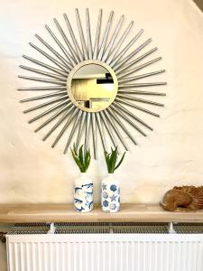 a mirror on a wall with two vases on a shelf at Suite Living Boardinghouse Apartments in Gießen