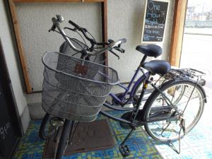 Una bicicleta con una cesta estacionada frente a una puerta en Moritomizu Backpackers, en Nagano