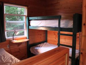 a bedroom with two bunk beds in a log cabin at New Glasgow Highlands Campground cabins in New Glasgow