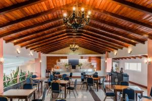 a dining room with tables and chairs and a chandelier at Hotel Libertador in Loja