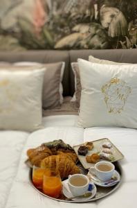 a tray of breakfast foods on a bed at NM Luxury Suites in Pompei