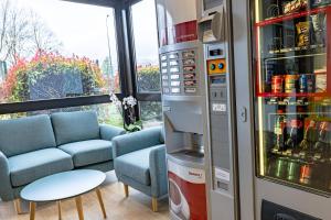 a living room with a refrigerator and a couch at Vini Hotel in Beaune