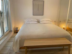 a bedroom with a large bed with a wooden bench at Shi Ti Junior Suite in Iaşi