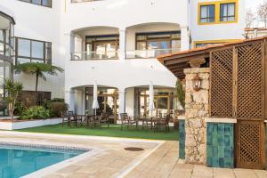 an exterior view of a house with a swimming pool at Clube do Lago Hotel in Estoril