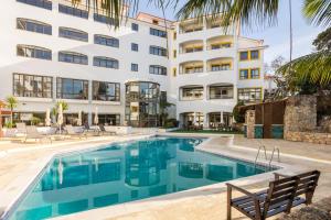 a swimming pool in front of a building at Clube do Lago Hotel in Estoril