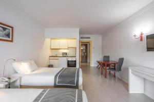 a hotel room with two beds and a table at Clube do Lago Hotel in Estoril