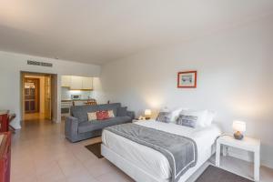 a bedroom with a bed and a living room with a couch at Clube do Lago Hotel in Estoril