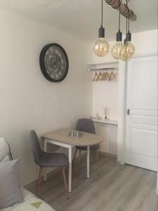 a room with a table and two chairs and a clock at Studio Cosy à Orange in Orange