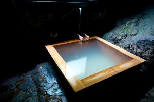 una caja de madera sobre una roca en Onsen Guesthouse HAKONE TENT, en Hakone