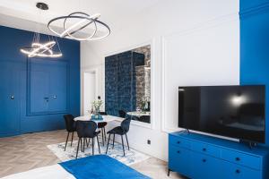 un soggiorno con tavolo, sedie e TV di Apartament 21A- Hvile Stay a Toruń