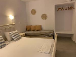 a small room with two beds and a couch at Nikoletta Studios in Agios Prokopios