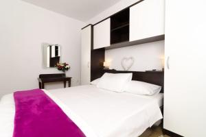 a bedroom with a large white bed with a purple blanket at Dubrovnik apartment Boo in Dubrovnik