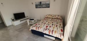 um quarto com uma cama e uma televisão de ecrã plano em Apartmani Naomi&Leo em Senj