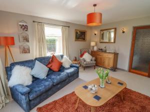 sala de estar con sofá azul y mesa en Robellen Corner, en Banbury