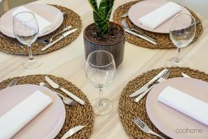 a table with plates and glasses and a potted plant at 14 Calçada de Santiago in Vila do Conde