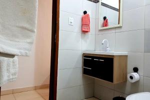 uma casa de banho com um lavatório e um espelho em Casa caiçara na Vila - Casa 01- Hospedaria da Vila em Ilhabela