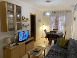 a living room with a couch and a tv at Amazing 2-bedrooms apartment with pool Torrevieja center in Torrevieja