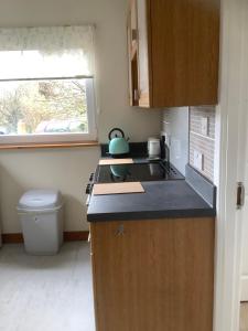 a small kitchen with a stove and a window at Croft cabin in Fort William