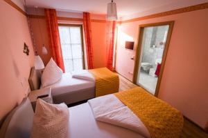 um quarto de hotel com duas camas e um espelho em Hotel Belle Vue Volkach em Volkach