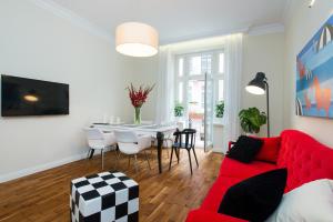sala de estar con sofá rojo y mesa en Style4rent Sunny Old Town Apartments, en Cracovia